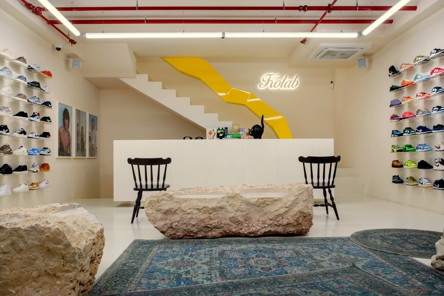 Inside Kolab: sneaker-lined walls, natural stone seating and the distinctive yellow staircase